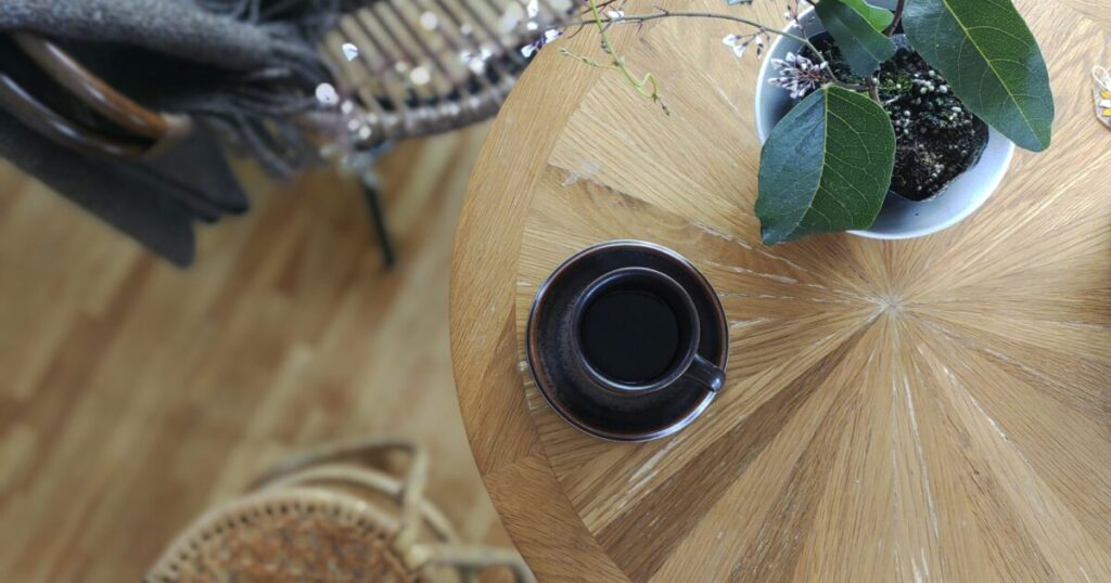 観葉植物とカフェテーブルのコーヒーカップ