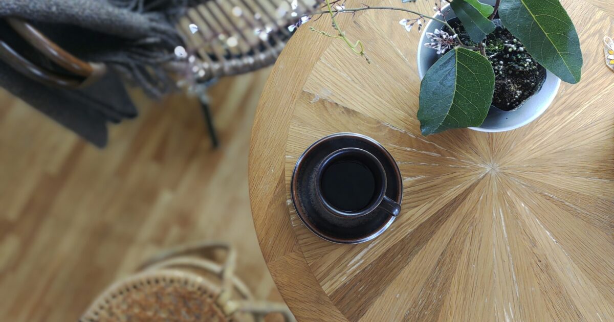 観葉植物とカフェテーブルのコーヒーカップ