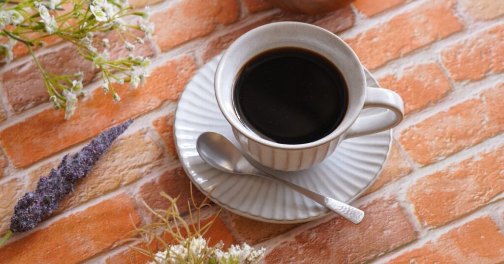 花と並べたカップコーヒーのテーブルコーディネート