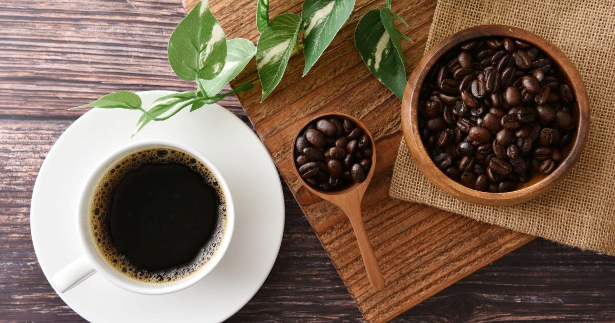 観葉植物とコーヒーカップと焙煎豆のテーブル