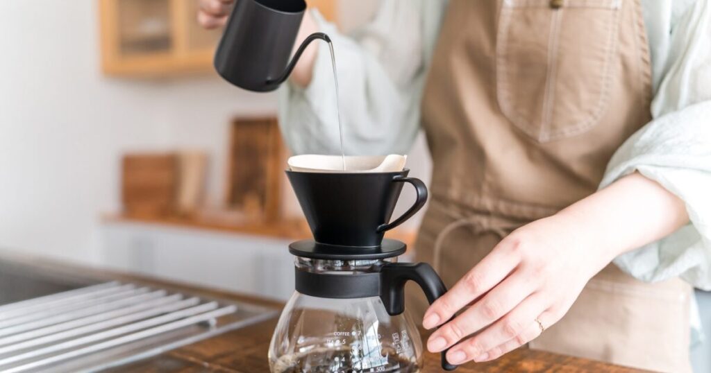 ハンドドリップでコーヒーを淹れる女性の手元