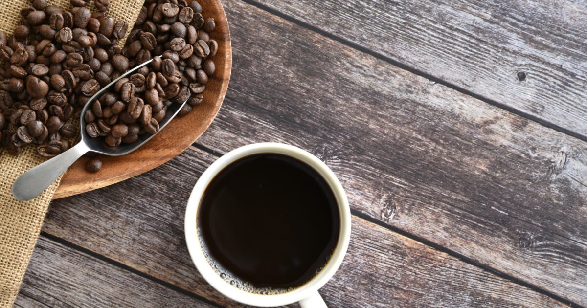 コーヒーカップと麻袋に盛られた焙煎豆