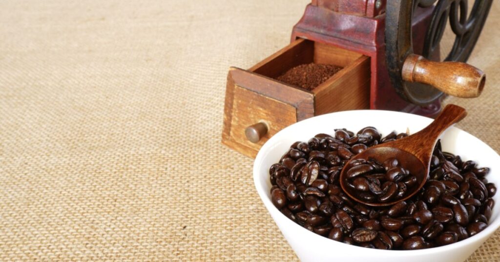 コーヒーミルと艶のある深煎り豆のボウル