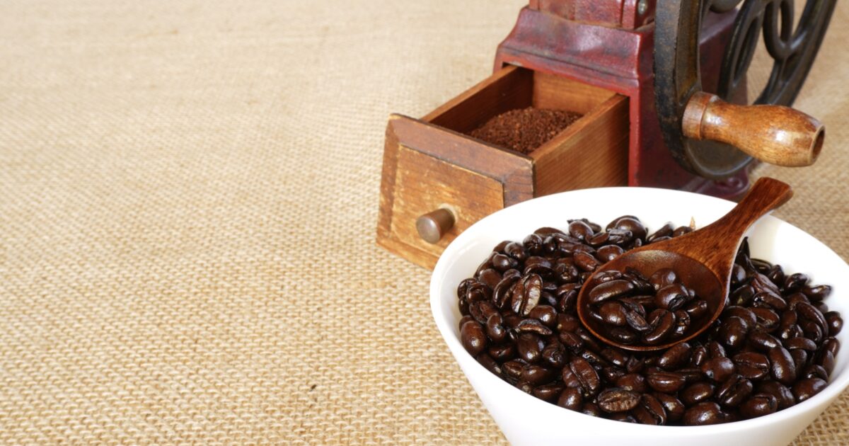 コーヒーミルと艶のある深煎り豆のボウル