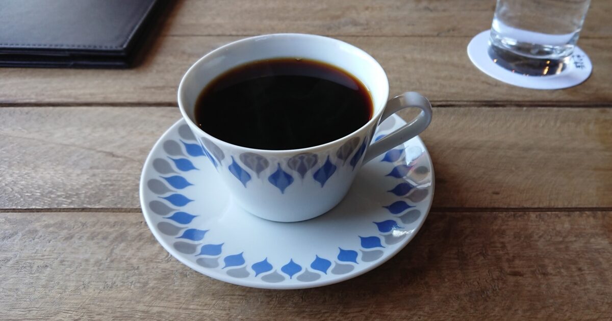 木製テーブルに置かれたカップコーヒーとソーサー