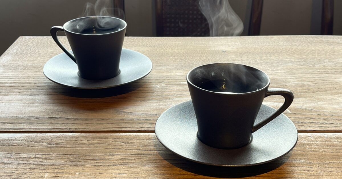 テーブルに置かれた黒いカップのホットコーヒー