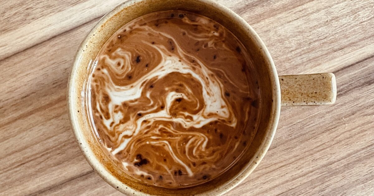 マグカップに注がれたミルク入りのコーヒー