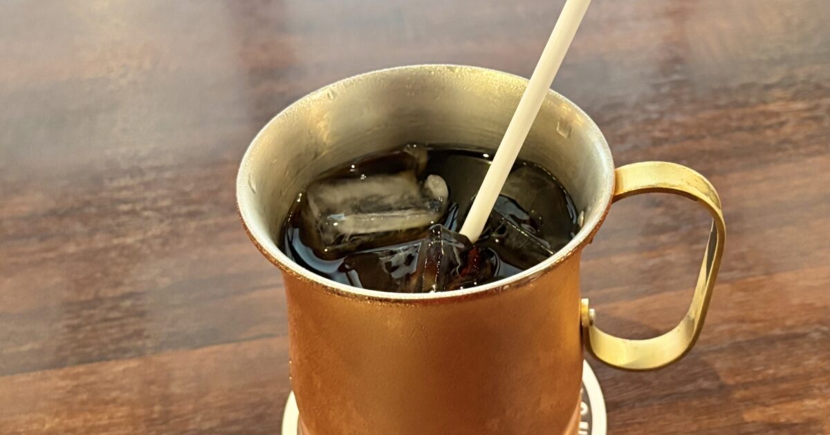 銅マグカップに入ったアイスコーヒーとストロー