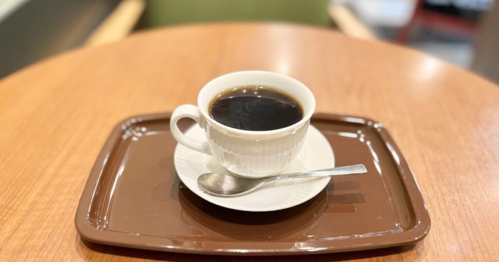 カフェのテーブルに置かれた白いカップのコーヒー