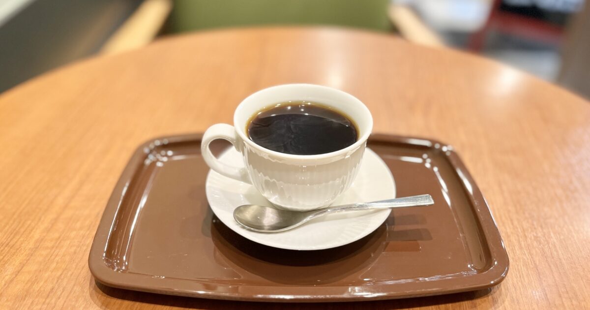 カフェのテーブルに置かれた白いカップのコーヒー