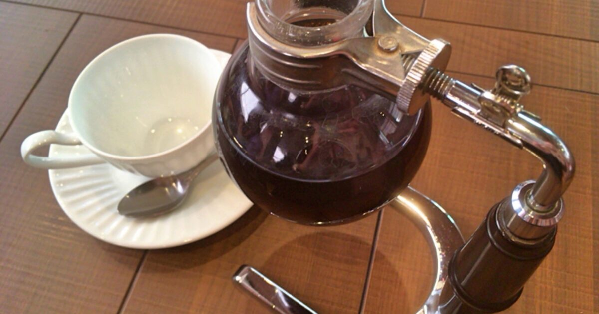 サイフォンに入ったコーヒーと白いカップのセット