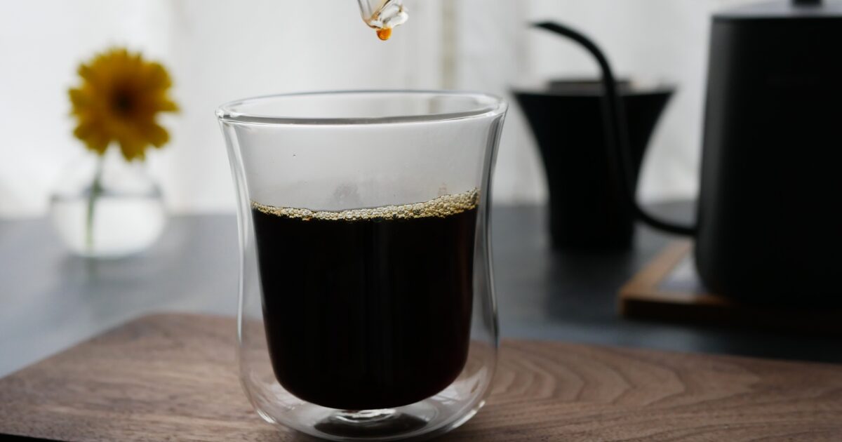 ガラスカップに注がれるハンドドリップのブラックコーヒー