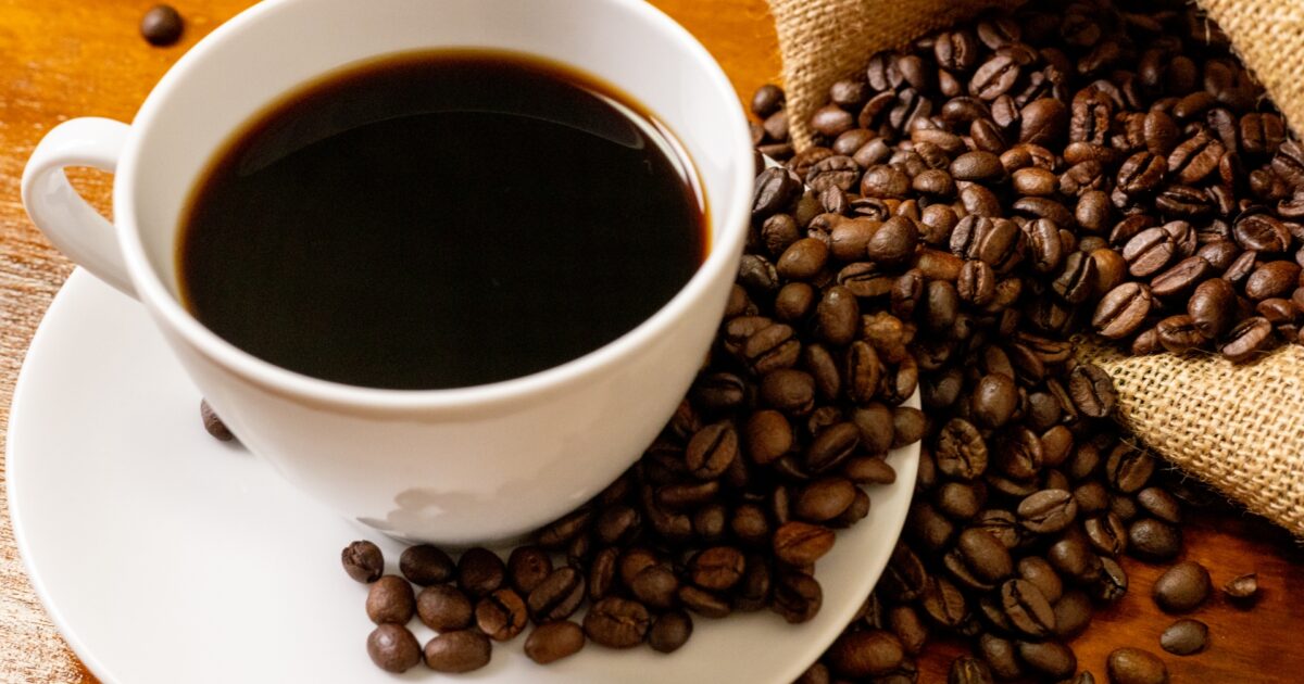コーヒーカップとこぼれた焙煎コーヒー豆